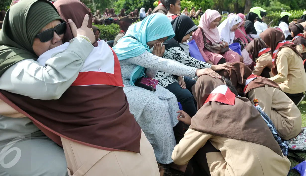 Seorang anggota pramuka (kiri) memeluk sang ibu yang tunanetra dalam kegiatan "Membasuh Kaki Ibu" secara massal  di Taman Wiladatika Cibubur, Jakarta, Rabu (21/12). Aksi massal itu dalam rangka memperingati Hari Ibu 2016. (Liputan6.com/Yoppy Renato)