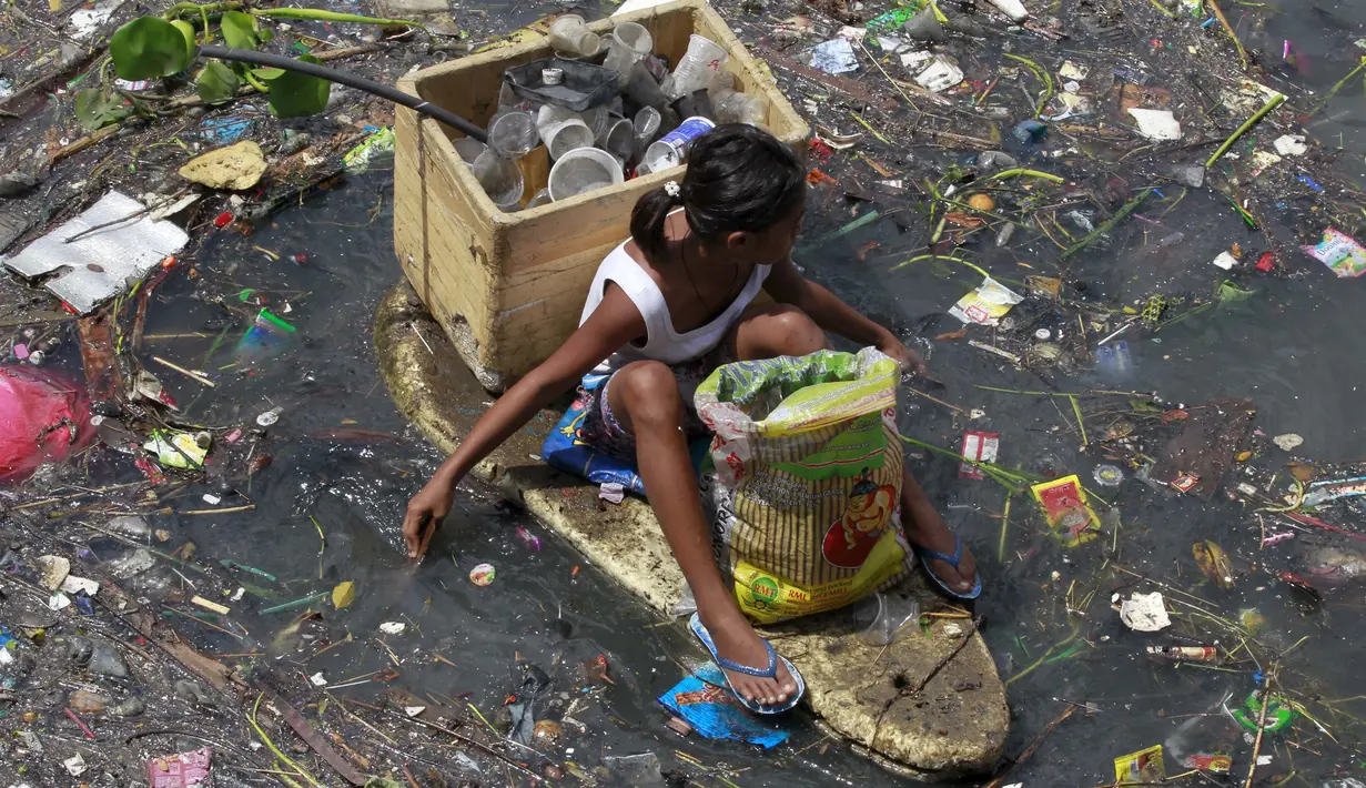 Seorang anak duduk di perahu darurat saat mengumpulkan sampah untuk bahan daur ulang di sebuah sungai yang tercemar di kota navotas, Manila, Kamis (2/7/2015). Daur ulang bertujuan untuk mengurangi tingkat pencemaran sungai. (REUTERS/Romeo Ranoco)