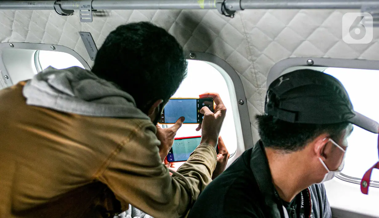 Sejumlah awak media memantau proses pencarian pesawat Sriwijaya Air SJ 182 dari pesawat CN 295 milik TNI AU di perairan Kepulauan Seribu, Jakarta, Minggu (10/1/2021). Menurut TNI AU, proses pencarian Sriwijaya Air SJ 182 bisa bertambah atau berkurang tergantung kondisi. (Liputan6.com/Faizal Fanani)