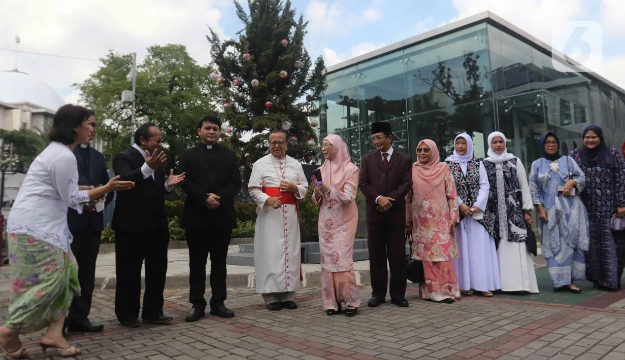 Istri Perdana Menteri Malaysia, Wan Azizah Wan Ismail disambut oleh Uskup Agung Jakarta Kardinal Ignatius Suharyo bersama Imam Besar Masjid Istiqlal Nasaruddin Umar bersiap berfoto bersama dengan latar belakang Gereja Katedral, Jakarta, Senin (9/1/2023). (Liputan6.com/Herman Zakharia)