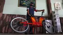 Mujahid (60) berfoto dengan sepeda listrik sigma buatannya di Pondok Gede, Bekasi, Jawa Barat, (15/9/2020). Sepeda listrik sigma berkapasitas 1.000 watt tersebut mampu menempuh jarak 60 Km dengan harga perakitan sebesar Rp 10 Juta. (Liputan6.com/Herman Zakharia)