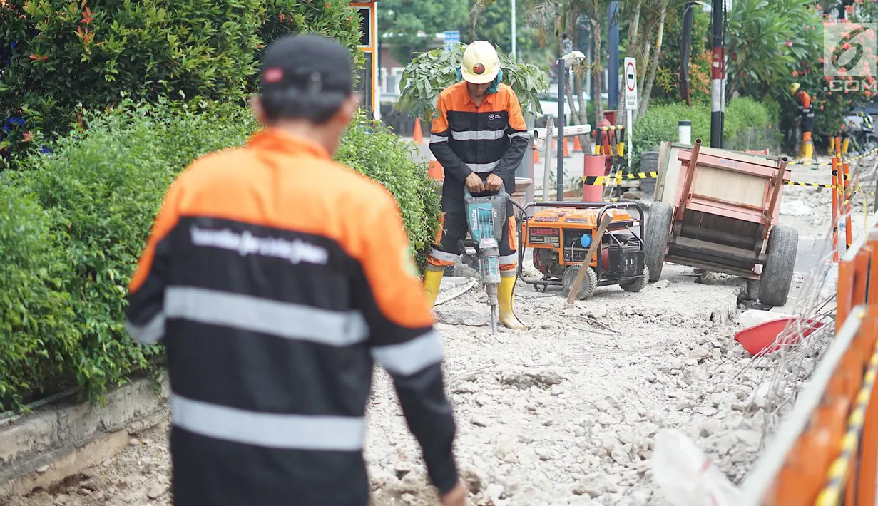 Aktivitas pekerja membongkar jalur pejalan kaki (trotoar) di Jalan Cikini Raya, Jakarta, Jumat (14/6/2019). Pemprov DKI bakal melakukan revitalisasi  trotoar di Jalan Cikini Raya dan Jalan Kramat Raya sepanjang 10 kilometer dengan anggaran sebesar Rp75 miliar. (Liputan6.com/Immanuel Antonius)