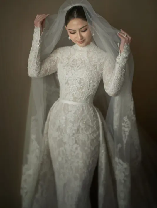 Gaun pengantin dengan kerah tinggi dan full renda itu disulam dengan tangan. Dilengkapi dengan train serta veil yang sama panjangnya. [Foto: IG/yeftagunawan].