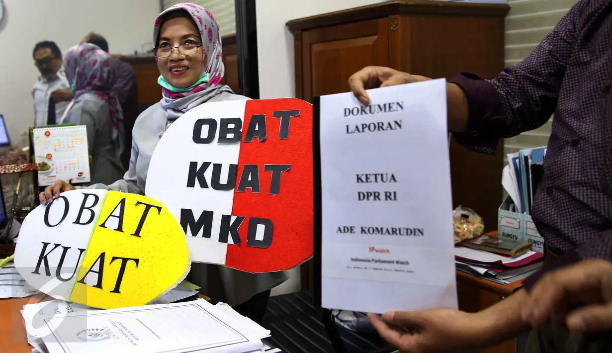 Pegawai MKD menunjukkan dokumen laporan dan simbolik obat kuat yang diberikan oleh sejumlah orangdari Indonesia Parlemen Watch (IP Watch) di Kompleks Parlemen, Jakarta, Kamis (24/11). (Liputan6.com/Johan Tallo)