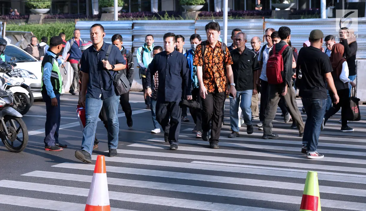 Warga melintasi Pelican Crossing di sekitar Halte Transjakarta Gelora Bung Karno, Jakarta, Jumat, (30/11). Penyeberangan pelican crossing diberlakukan selama revitalisasi jembatan penyeberangan orang (JPO) berlangsung. (Liputan6.com/Helmi Fithriansyah)