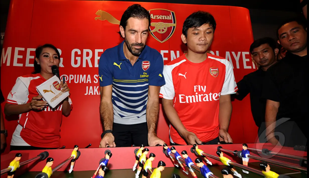 Pires bermain Foosball dengan salah satu fans Arsenal saat konfrensi pers terkait promosi tur pramusim Arsenal di Kota Kasablangka, Jakarta, Jumat (23/1/2015). (Liputan6.com/Miftahul Hayat)