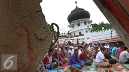 Warga memanfaatkan halaman Masjid Jami Quba untuk melaksanakan Salat Jumat, Aceh, Jumat (9/12). Gempa berkekuatan 6,5 SR telah merobohkan ratusan bangunan termasuk Masjid Jami Quba. (Liputan6.com/Angga Yuniar)