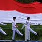 Anggota Paskibraka bersiap mengibarkan bendera merah putih di Sungai Cisadane, Kota Tangerang, Banten, Kamis (28/10/2021). Pengibaran bendera merah putih yang di ikuti puluhan pemuda tersebut di lakukan untuk memperingati hari sumpah pemuda. (Liputan6.com/Angga Yuniar)