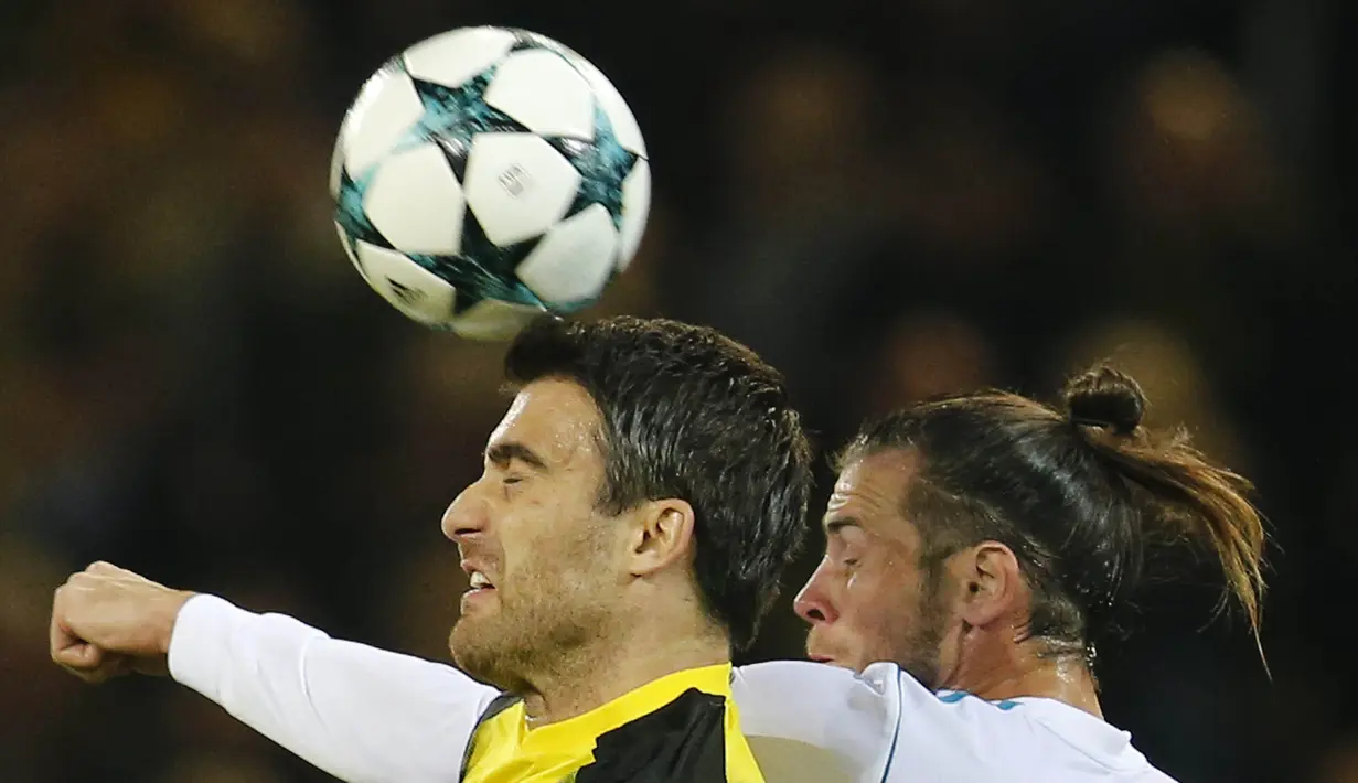 Gelandang Real Madrid, Gareth Bale, duel udara dengan bek Dortmund Sokratis Papastathopoulos, pada laga Liga Champions di Stadion Signal Iduna Park, Dortmund, Selasa (26/9/2017). Dortmund kalah 1-3 dari Madrid. (AP/Michael Probst)
