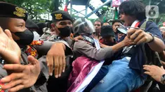 Mahasiswa berusaha menerobos barikade polisi yang dikerahkan dalam demonstrasi menolak kenaikan harga BBM di kawasan Patung Kuda, Jakarta, Kamis (8/9/2022). Sempat memanas, aksi saling dorong massa dengan petugas kepolisian pun tak terhindarkan. (merdeka.com/Arie Basuki)