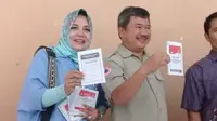 Bupati Garut Rudy Gunawan dan Istrinya Diah Kurniasari tetap mesra selepas memberikan pencoblosan di TPS jalan Kabupaten (Liputan6.com/Jayadi Supriadin)