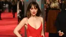 Aktris AS, Dakota Johnson berpose di red carpet ajang British Academy of Film and Television Arts (BAFTA) 2016 di London, Minggu (14/2). Nominator kategori Rising Star itu tampil dalam balutan gaun merah berbelahan dada rendah. (AFP/Justin Tallis)