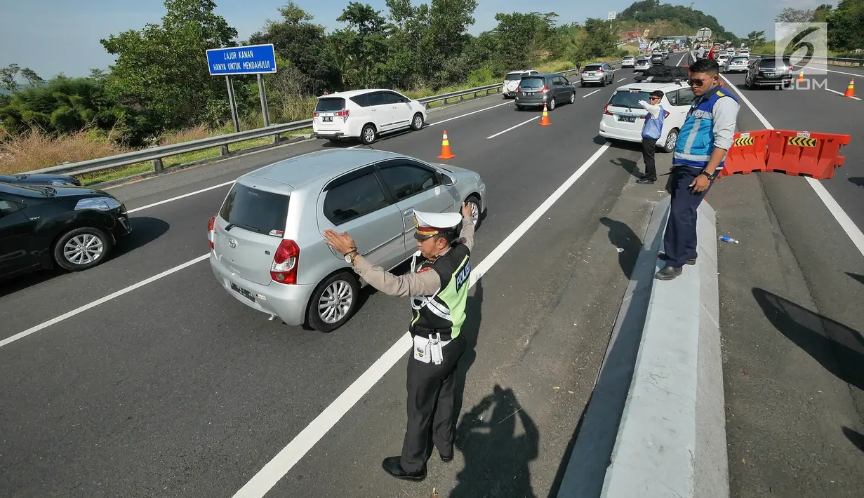 Petugas mengatur pemberlakukan jalur contra flow di ruas tol Semarang-Bawen, Jawa Tengah, Jumat (31/5/2019). Jasa Marga memberlakukan rekayasa lalu lintas sistem lawan arus dari Km 426 hingga Km 433 ruas tol Semarang-Bawen guna mengurai kepadatan kendaraan pemudik. (Liputan6.com/Herman Zakharia)