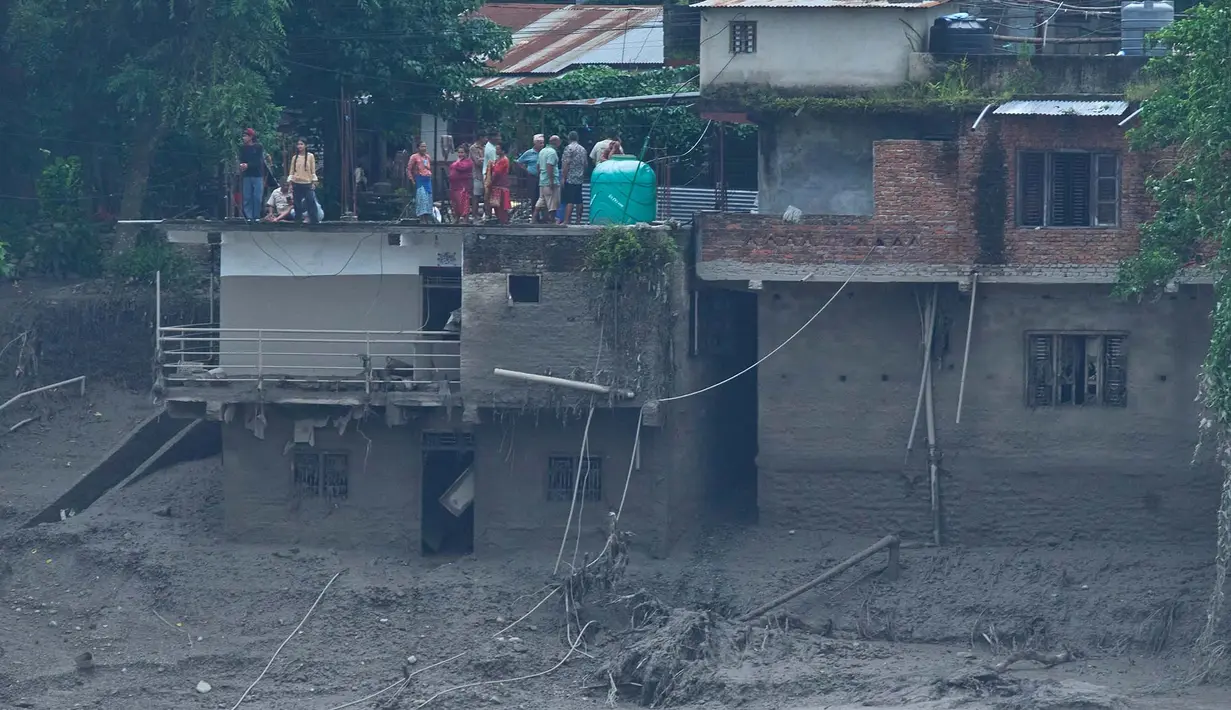 Warga melihat kerusakan akibat banjir bandang di sepanjang Sungai Trishuli di distrik Nuwakot, Nepal, Rabu, 26 Agustus 2026. (Foto AP/Niranjan Shrestha)