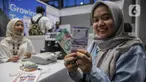 Warga menunjukkan uang rupiah baru usai melakukan penukaran di Hall Basket, Kompleks Gelora Bung Karno, Senayan, Jakarta, Jumat (21/3/2025). (Liputan6.com/Angga Yuniar)
