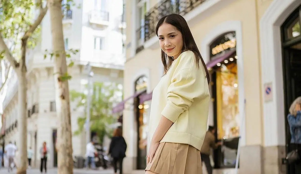 Atau ingat pengampilan satu ini saat Nagita pergi keluar negeri? Ia tampil bak remaja dengan sweater kuning dan mini pleated skirt cokelat, dipadukan dengan kaus kaki panjang hijau, serta sneakers yang serasi. [Foto: Instagram/pecintaladygigi]