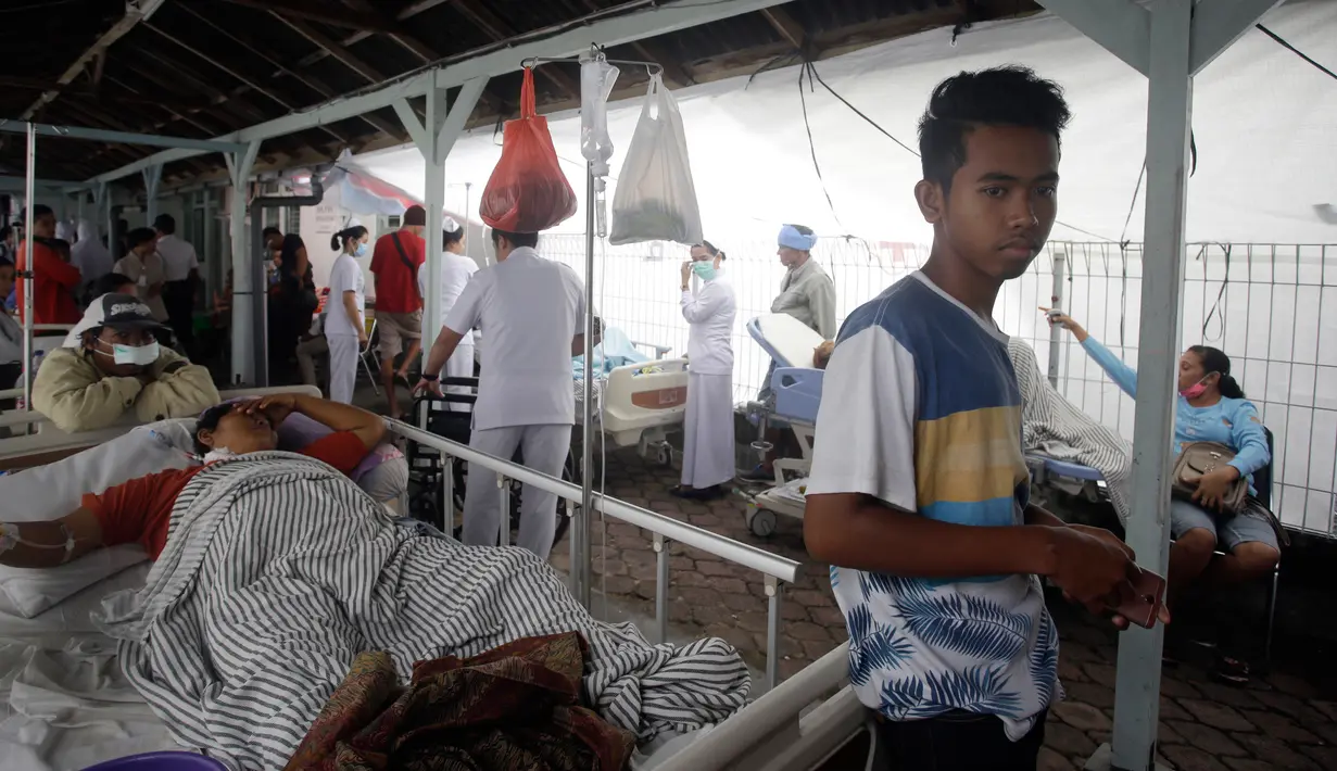 Pasien dievakuasi keluar rumah sakit di Bali menyusul gempa Lombok, Senin (6/8). Gempa 7 pada skala richter yang berpusat di Lombok, menyebabkan kerusakan bangunan di berbagai lokasi di Bali dan mengakibatkan sejumlah warga terluka. (AP/Firdia Lisnawati)