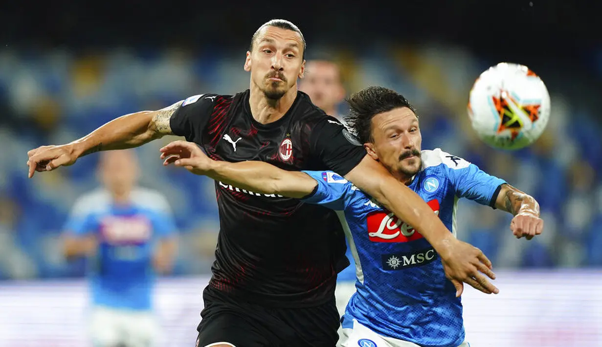 Striker AC Milan, Zlatan Ibrahimovic, berebut bola dengan  pemain Napoli, Mario Rui, pada laga Serie A di Stadion San Paolo, Minggu, (12/7/2020). Kedua tim bermain imbang 2-2. (Spada/LaPresse via AP)