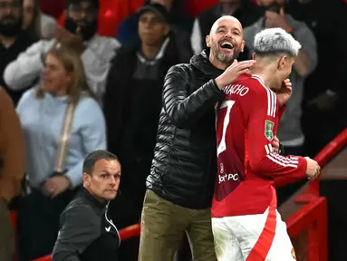 Pelatih Manchester United, Erik ten Hag bercanda dengan pemainnya, Alejandro Garnacho saat pergantian pemain pada laga Carabao Cup 2024/2025 melawan Barnsley di Old Trafford, Manchester, Inggris, Rabu (18/09/2024) WIB. (AFP/Paul Ellis)