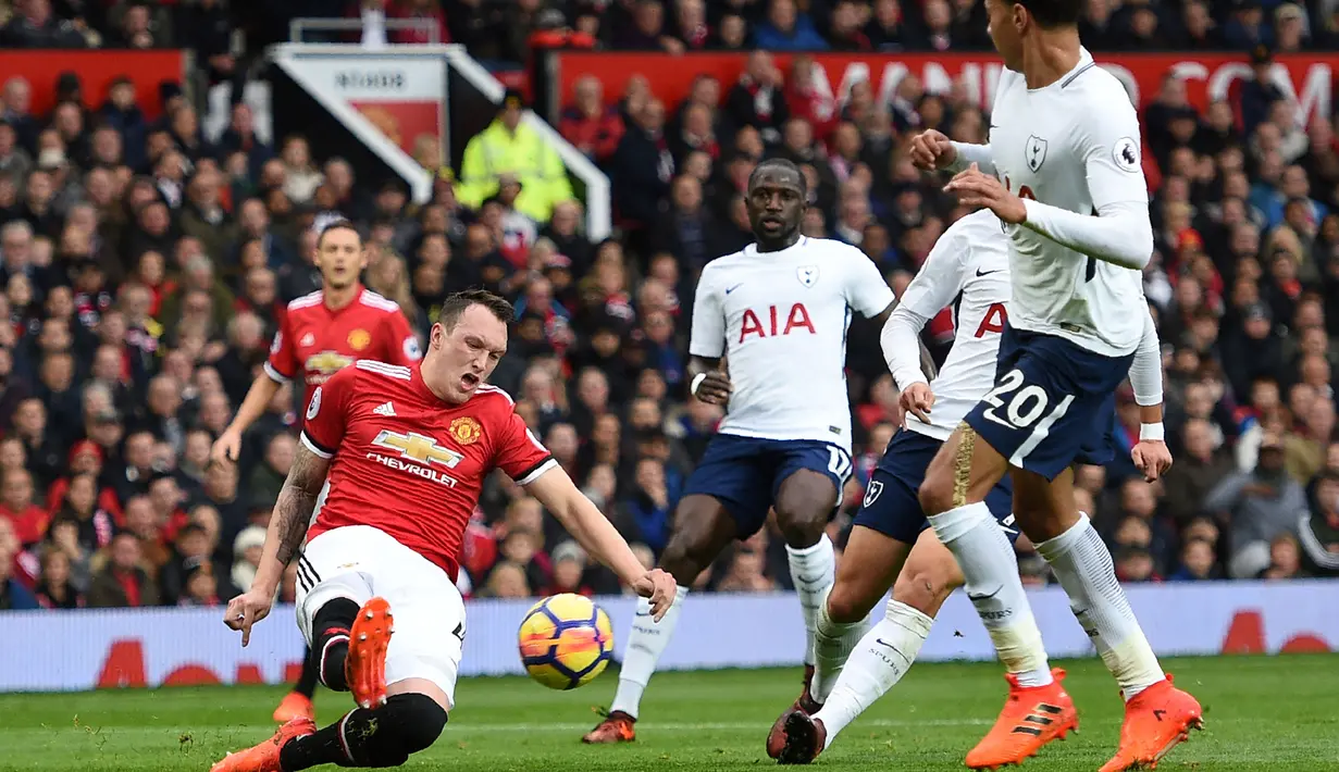 Pemain Manchester United, Phil Jones (kiri), berhasil menghalau bola dari serangan pemain Tottenham Hotspur dalam pertandingan lanjutan Liga Inggris 2017/2018 yang berlangsung di Old Trafford, Sabtu (28/10/2017). (AFP/Oli Scarff)