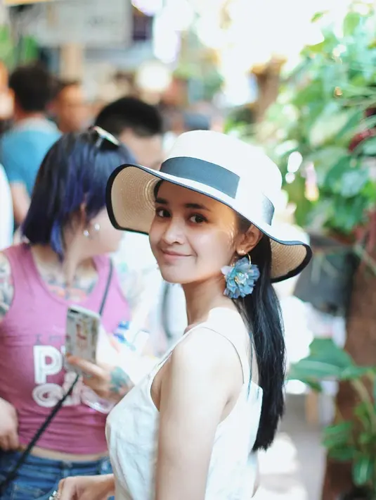 Bucket hat rajut menjadi salah satu fashion item yang manis untuk berlibur. Dipadukan dengan dress berwarna putih tulang, membuat pemain film Mekah I'm Coming tampil lebih memesona. (Liputan6.com/IG/@michelleziu)