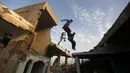 Aksi Parkaour remaja Palestina di bekas gedung yang hancur akibat serangan roket Israel. Foto diambil pada Jumat (14/11/2014) (AFP Photo/Mohammed Abed)