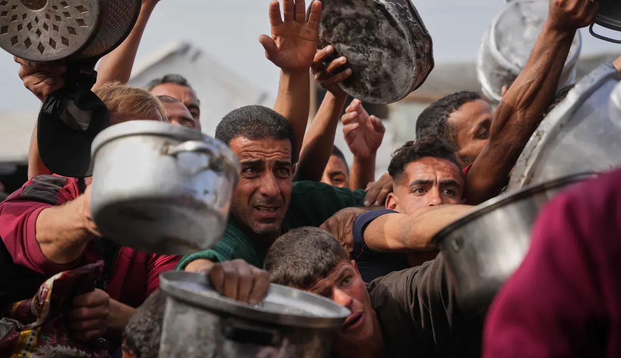 Badan PBB untuk Pengungsi Palestina (UNRWA) mengatakan, upaya mereka untuk menyalurkan bantuan kemanusiaan ke Jalur Gaza masih terhambat akibat blokade Israel yang dilakukan sejak Maret 2025 lalu. Tampak dalam foto, warga Palestina berebut menerima makanan sumbangan di dapur umum, Khan Younis, Jalur Gaza selatan, Jumat 6 Februari 2026. (AP Photo/Abdel Kareem Hana)