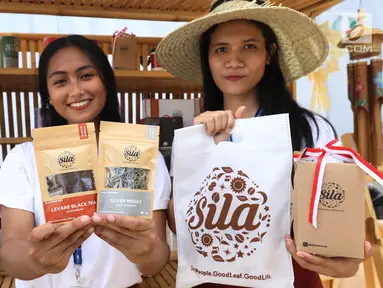 SPG menunjukkan produk teh milik Holding Perkebunan Nusantara (PTPN Group) di Indonesia Pavilion saat  IMF-World Bank 2018, Nusa Dua, Bali, Kamis (11/10). PTPN Group menyediakan Kopi Rollaas Jawa Timur dan Teh Sila. (Liputan6.com/Angga Yuniar)