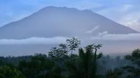Pemandangan Gunung Agung dari Karangasem di pulau resor Bali, Indonesia (24/9). Gunung Agung adalah satu dari sekian banyak gunung berapi di Indonesia dan wilayah Cincin Api yang mengelilingi Pasifik dan samudera timur India. (AFP Photo/Sonny Tumbelaka)