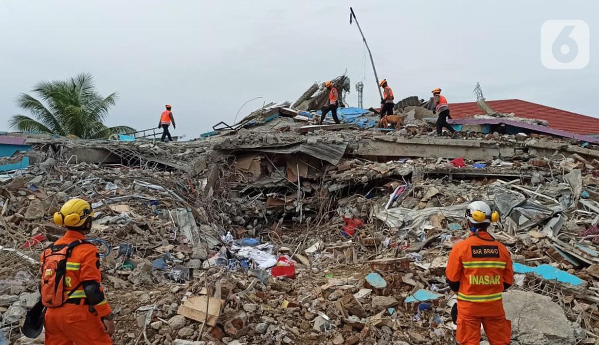 Anjing polisi K-9 mengendus bangunan yang runtuh akibat gempa bumi saat proses pencarian korban di Rumah Sakit Mitra Manakarra di Mamuju, Minggu (17/1/2021). Polri mengerahkan enam ekor K-9 untuk membantu menangani dampak gempa di Majene dan Mamuju, Sulawesi Barat. (Liputan6.com/Abdul Rajab Umar)