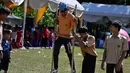Siswa mengikuti permainan tradisional egrang pada Festival Permainan Tradisional Anak di Desa Wisata Lubok Sukon, Kecamatan Ingin Jaya, Aceh Besar, Aceh, Sabtu (25/7/2026). (AFP/ Chaideer Mahyuddin)