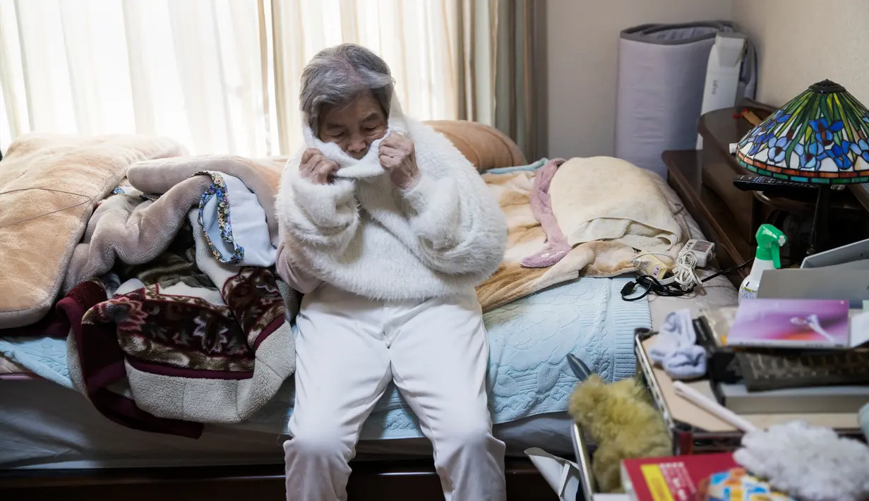 Seorang nenek bernama Kimiko Nishimoto mengenakan kostum bersiap untuk melakukan sesi pemotretan di rumahnya di kota Kumamoto, Jepang (16/1). (AFP Photo/Behrouz Mehri)