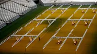 Seorang pria bekerja di lapangan Lusail Stadium, Lusail, Qatar, 28 Maret 2022. Stadion berkapasitas 80 ribu penonton yang terletak di pinggiran Ibu Kota Doha ini akan menjadi tuan rumah final Piala Dunia 2022 pada bulan Desember mendatang. (GABRIEL BOUYS/AFP)
