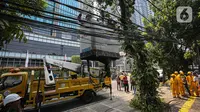 Beragam jenis kabel, terutama kabel fiber optik, tampak tumpang-tindih atau semrawut, bahkan menjuntai di atas jalanan di Jakarta. (Liputan6.com/Faizal Fanani)