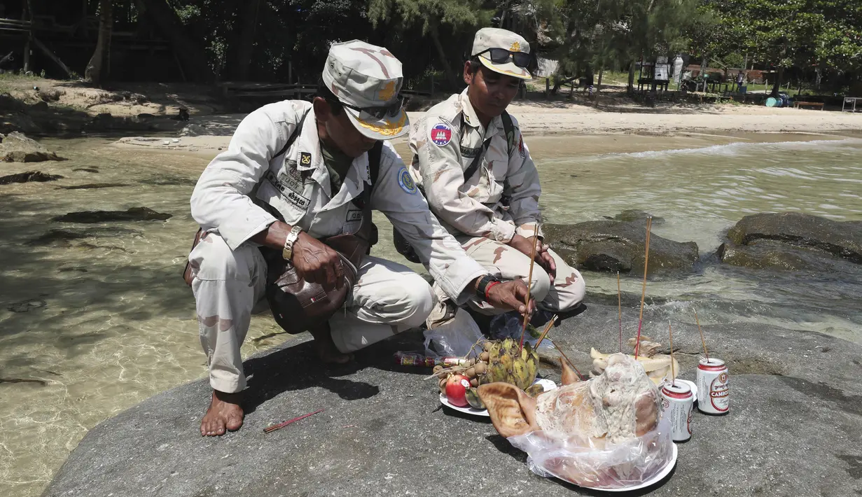 Tentara Kamboja berdoa dengan harapan menemukan warga negara Inggris Amelia Bambridge di pulau Koh Rong di barat daya Kamboja (29/10/2019). Amelia Bambridge hilang ketika menghadiri pesta pantai di pulau Koh Rong yang diikuti wisatawan dari berbagai negara. (AP Photo/Heng Sinith)