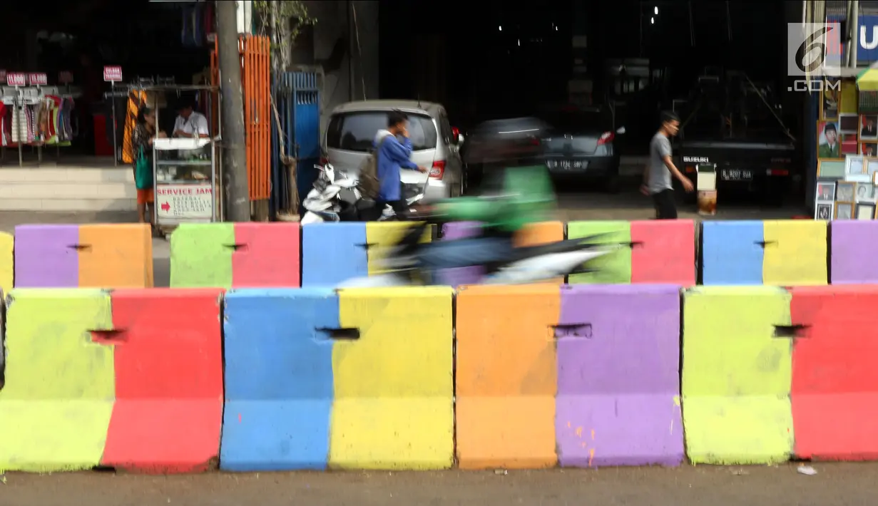 Kondisi pemisah jalan yang dicat warna warni di Jalan Raya Ragunan sekitar Pasar Minggu, Jakarta, Selasa (24/7). Di kawasan ini pemisah jalan di cat warna warni sehingga terlihat lebih semarak. (Liputan6.com/Helmi Fithriansyah)