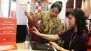 Komisaris Utama Batik Keris Lina Handianto Tjokrosaputro bersama pegawai memperhatikan kemeja batik yang akan dipromosikan online pada acara Relaunching Batik Keris Online di Bekraf Habibie Festival 2017 Jakarta.(Liputan6.com/Pool)