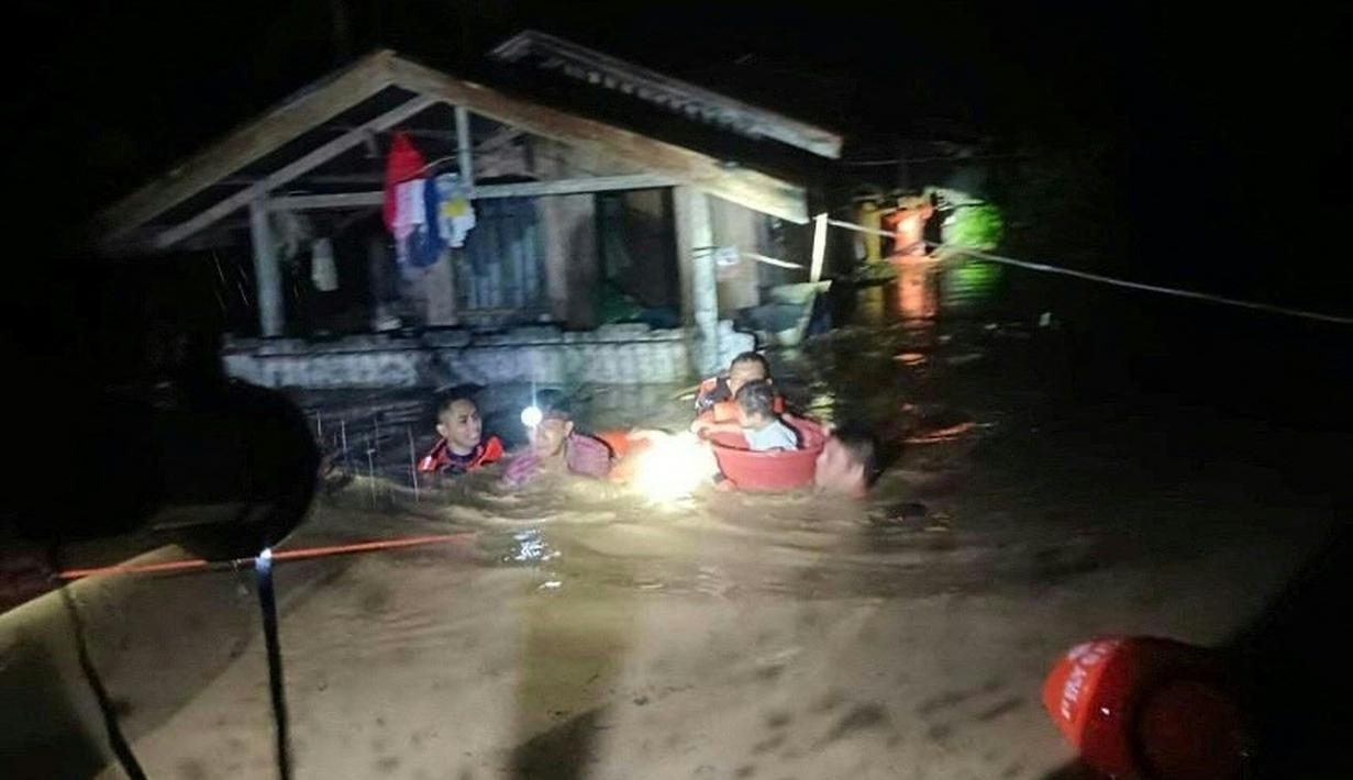 Penyelamat mengevakuasi orang-orang dari daerah banjir di Kota Ozamiz, Misamis Occidental, Filipina (25/12/2022). Dua orang tewas dan hampir 46.000 lainnya meninggalkan rumah mereka saat banjir pada libur Hari Natal. (Handout / Philippine Coast Guard (PCG) / AFP)