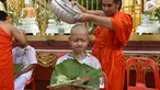 Biksu mengguyur kepala salah satu anak, yang diselamatkan dari gua di Thailand, pada upacara pentahbisan di Kuil Wat Phra That Doi Wao, Chiang Rai, Selasa (24/7). Sebanyak 11 remaja menjalani ritual menjadi biksu. (Panumas Sanguanwong/THAI NEWS PIX/AFP)