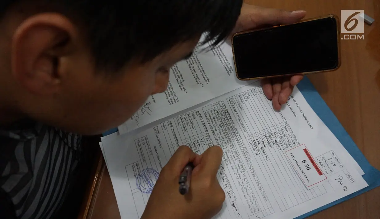 Warga mengisi dokumen saat mengurus surat pindah tempat memilih atau Formulir A5 Pemilu 2019 di Kantor KPUD Jakarta Selatan, Jakarta, Rabu (10/4). Hari ini merupakan batas akhir pembuatan Formulir A5. (Liputan6.com/Herman Zakharia)