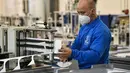 Seorang karyawan mengontrol produksi masker FFP2 untuk melawan pandemi COVID-19 di produsen masker Sentias di Wuppertal, Jerman, Kamis (28/1/2021). Jerman mewajibkan masker medis jenis KN95 atau FFP2 digunakan saat bepergian dengan transportasi umum atau perbelanjaan. (AP Photo/Martin Meissner)