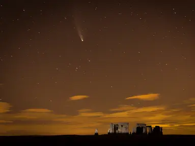 Foto yang diabadikan pada 23 Juli 2020 ini memperlihatkan Komet Neowise di atas monumen Stonehenge di Wiltshire, Inggris. Fenomena ini cukup langka karena membutuhkan waktu 6.800 tahun lagi untuk dapat kembali mendekati orbit Bumi. (Xinhua/Tim Ireland)