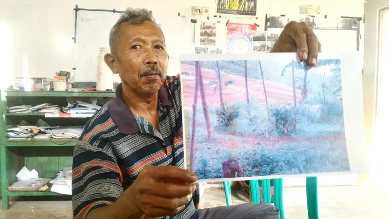 Direktur LSM Setam, Petrus Sugeng memperlihatkan foto tanah yang disengketakan antara warga Wanareja dengan Perhutani. (Foto: Liputan6.com/Muhamad Ridlo).