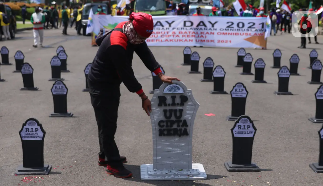 Buruh meletakkan puluhan nisan di sekitar area Monas, Jakarta, pada Hari Buruh Internasional, Sabtu (1/5/2021). Nisan hitam itu dihiasi tulisan yang mewakili perasaan para buruh, Antara lain RIP PHK Murah, Bebasnya Outsourcing, RIP Cuti Hamil, RIP Satuan Upah-Perjam. (Liputan6.com/Angga Yuniar)