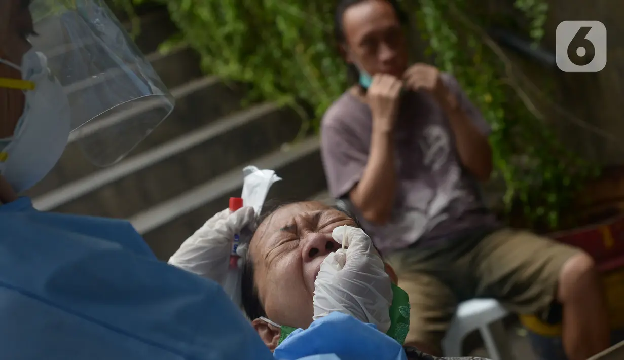 Petugas Puskesmas Taman Sari melakukan skrining Covid-19 dengan swab tes dan PCR di pusat perniagaan Glodok, Jakarta, Jumat (11/2/2022). Pemerintah terus berupaya memutus mata rantai penyebaran Covid-19 khususnya varian omicron untuk wilayah Taman Sari Jakarta Barat. (merdeka.com/Imam Buhori)