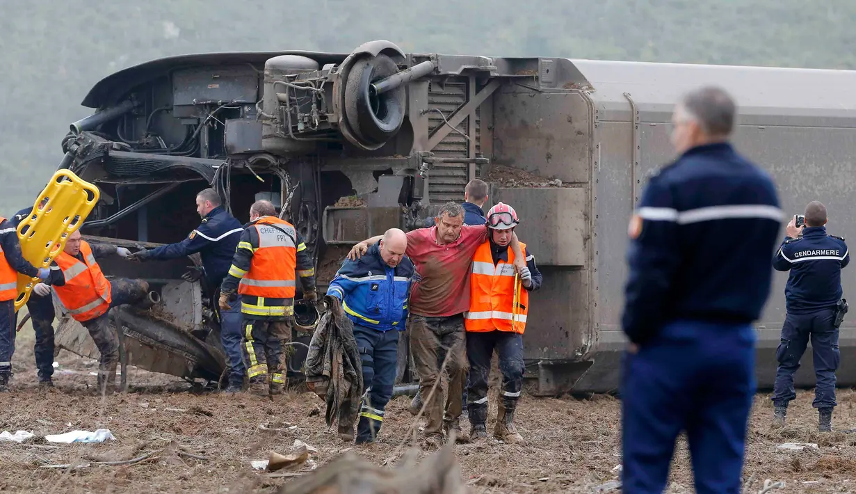 Petugas saat mengevakuasi korban yang selamat dari kereta yang jatuh di sungai dekat Strasbourg, Perancis, Sabtu (14/11/2015). Kereta itu membawa 49 teknisi kereta api. (REUTERS/Vincent Kessler)