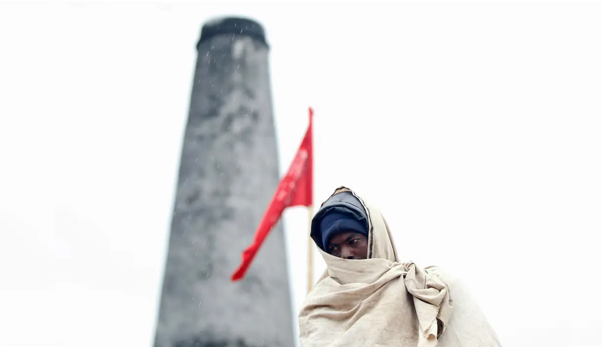 Pekerja migran India dengan terbungkus syal berada  di sebuah pabrik batu bata di pinggiran Kathmandu, Nepal. Ribuan pekerja migran India datang ke Nepal untuk bekerja di pabrik batu bata. (AP Photo/Niranjan Shrestha)