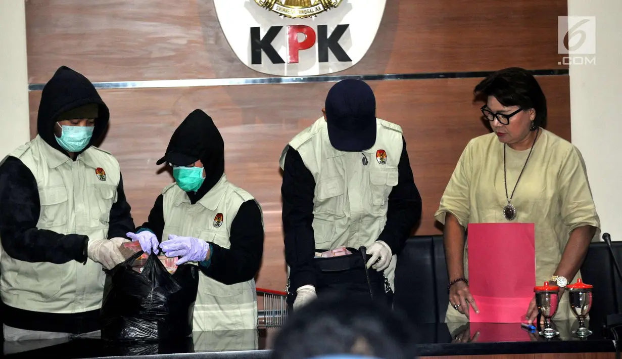 Wakil Ketua KPK Basaria Panjaitan (kanan) usai menunjukan barang bukti uang hasil OTT Walikota Cilegon, TB Iman Aryadi sebanyak Rp 1,15 Miliar, saat memberikan keterangan pers, di Gedung KPK, Jakarta, Sabtu (23/9). (Liputan6.com/Helmi Afandi)
