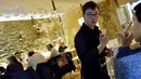 Seorang pelayan dengan down syndrome melayani pengunjung selama makan malam di restoran "Le Reflet", Nantes di Prancis Barat, 9 Februari 2017. Lelievre (26), mempekerjakan sejumlah karyawan yang memiliki down syndrome di restorannya. (LOIC VENANCE/AFP)