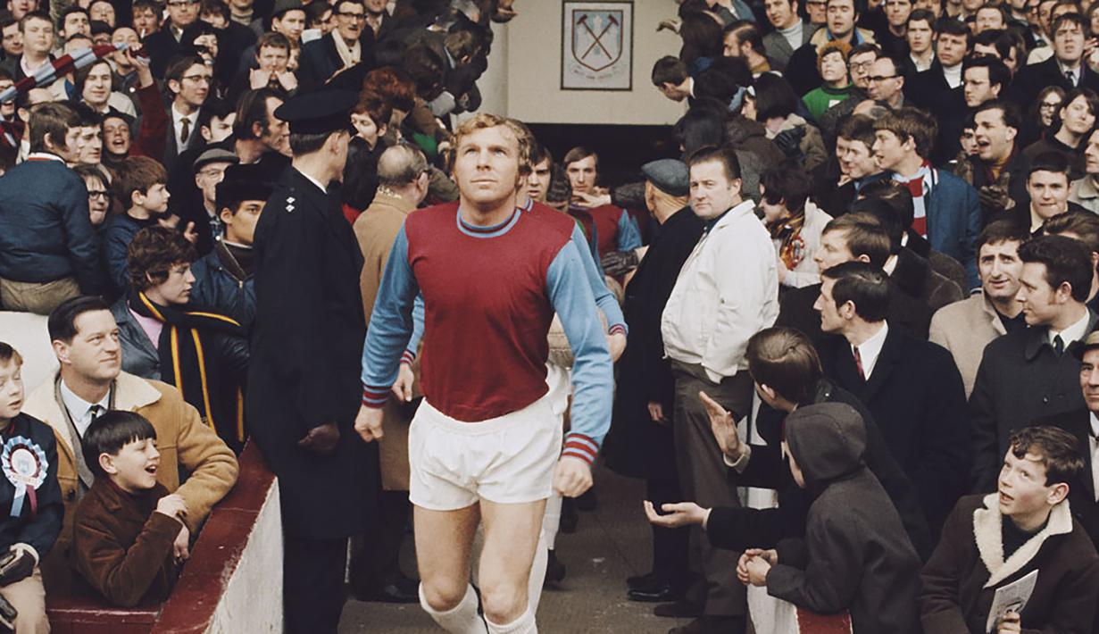 Bobby Moore. Legenda West Ham yang mengenakan jersey nomor 6 ini memperkuat The Hammers mulai 1958/1959 hingga 1973/1974 alias 16 musim. Ia juga menjadi kapten Timnas Inggris saat juara Piala Dunia 1966. Ia meninggal pada 1993, dan 2011 West Ham memensiunkan jersey bernomor 6. (Foto: whufc.com)
